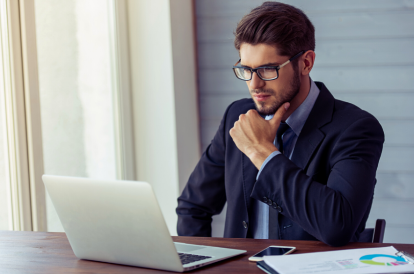 Confused businessman looking at his laptop