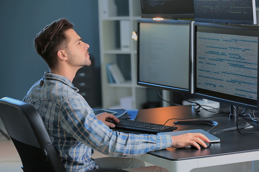 IT Engineer working on a multi monitor computer setup